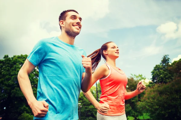 Sorridente coppia correre all'aperto — Foto Stock