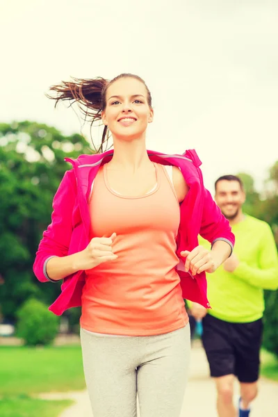 Smiling couple running outdoors — Stock Photo, Image