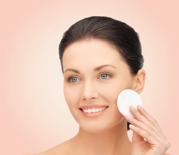 Mujer sonriente limpiando la piel de la cara con algodón — Foto de Stock