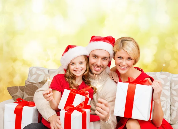 Lachende familie holding geschenkdozen en sparkles — Stockfoto