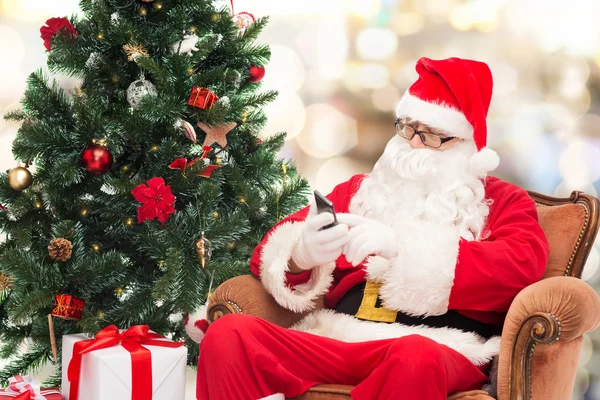 Santa Claus con smartphone y árbol de Navidad — Foto de Stock