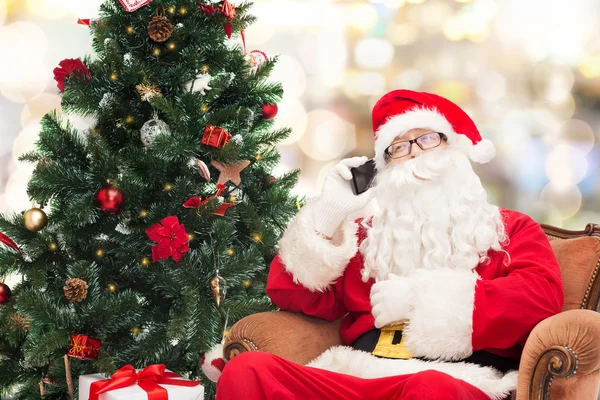 Santa claus s smartphone a vánoční stromeček — Stock fotografie