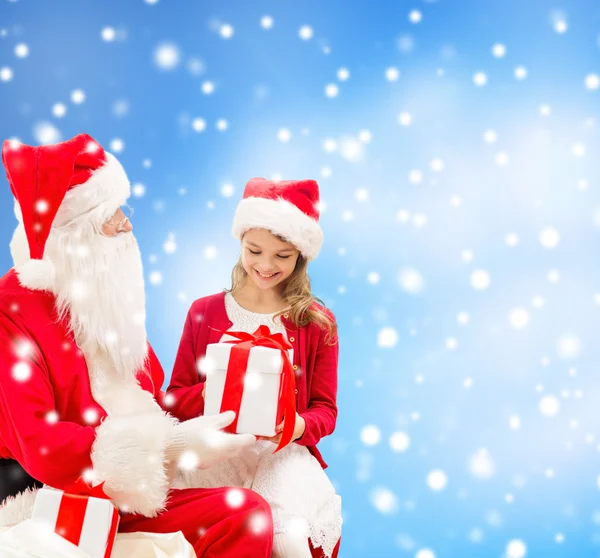 Niña sonriente con santa claus y regalos — Foto de Stock