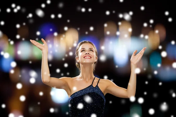 Smiling woman raising hands and looking up — Stock Photo, Image