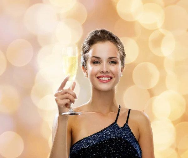 Sonriente mujer sosteniendo un vaso de vino espumoso —  Fotos de Stock