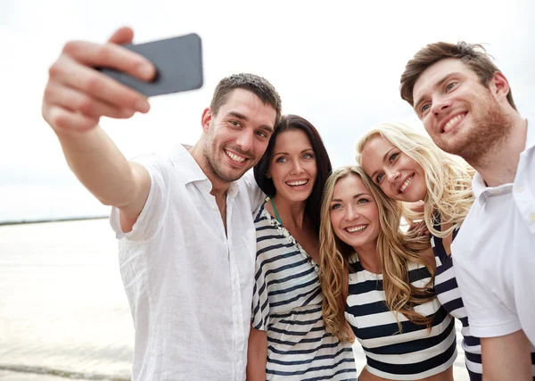 Amigos felizes na praia e tirar selfie — Fotografia de Stock