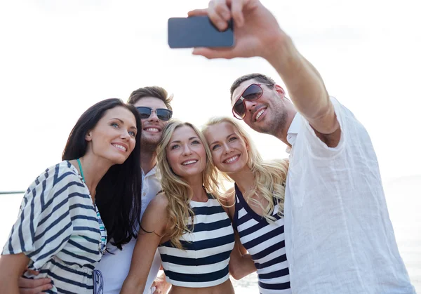 Amigos felices en la playa y tomar selfie —  Fotos de Stock