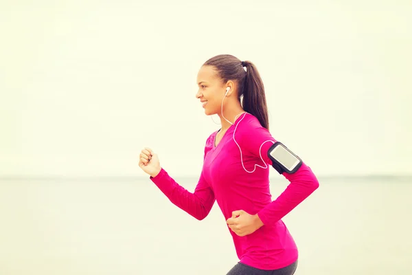 Usměvavá mladá žena běží venku — Stock fotografie
