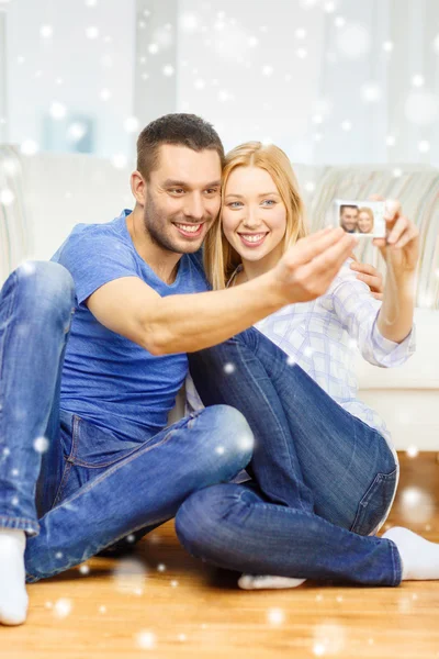 Couple souriant prenant des photos avec appareil photo numérique — Photo