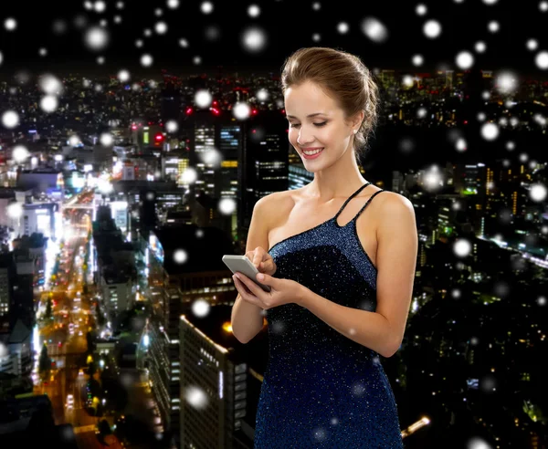 Smiling woman in evening dress with smartphone — Stock Photo, Image