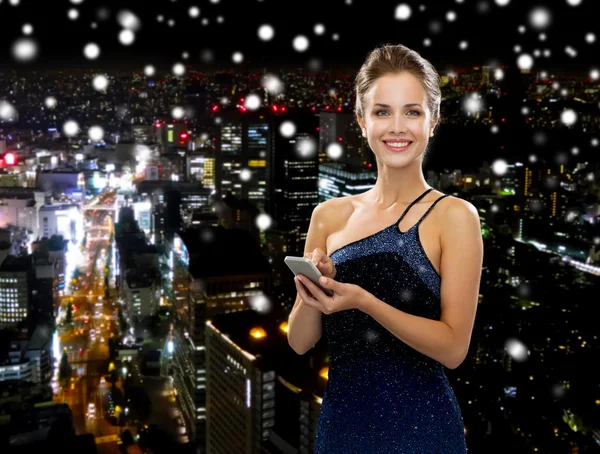 Smiling woman in evening dress with smartphone — Stock Photo, Image