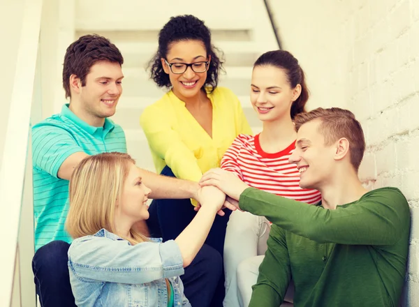 Étudiants souriants avec les mains les uns sur les autres — Photo