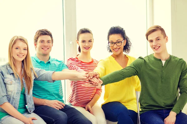 Étudiants souriants avec les mains les uns sur les autres — Photo