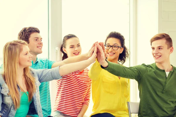 Sonriendo estudiantes haciendo alta cinco gesto sentado —  Fotos de Stock