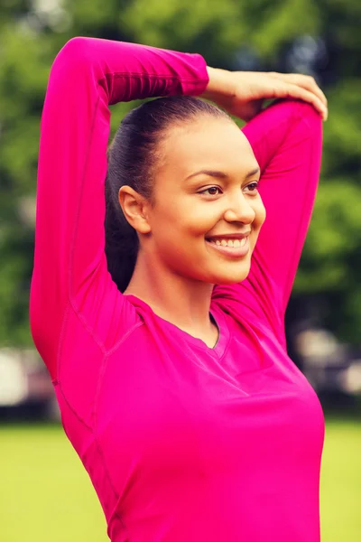 Sonriente negro mujer estirando la pierna al aire libre —  Fotos de Stock