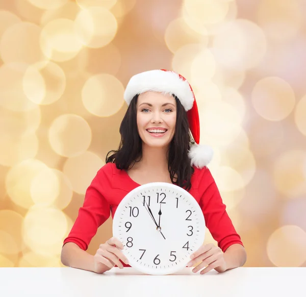 Lachende vrouw in helper kerstmuts met klok — Stockfoto