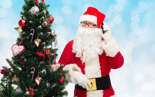 Санта-Клаус со смартфоном и елкой — стоковое фото