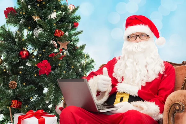 Man in costume of santa claus with laptop — Stock Photo, Image