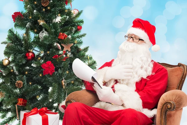 Man in costume of santa claus with notepad — Stock Photo, Image