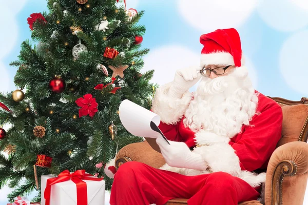 Homem em traje de santa claus com bloco de notas — Fotografia de Stock