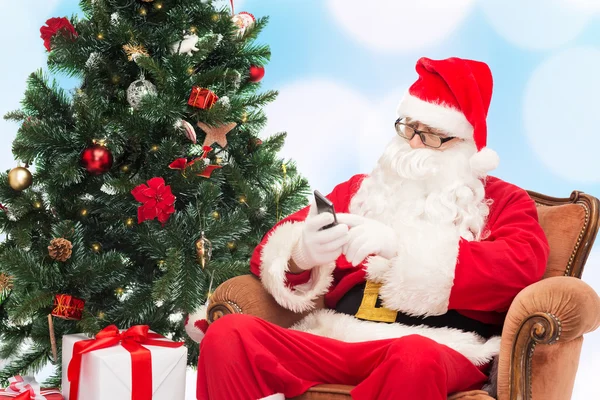 Santa Claus con smartphone y árbol de Navidad — Foto de Stock