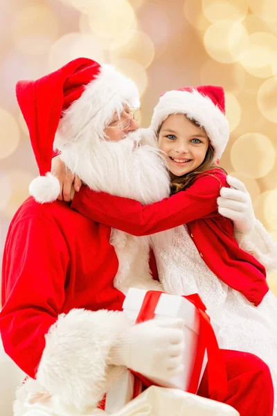 Lachende meisje met santa claus — Stockfoto