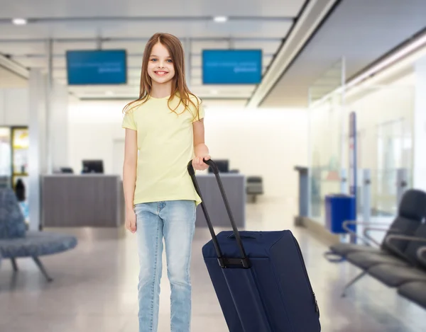 Usměvavá dívka s cestovní tašku na letišti — Stock fotografie