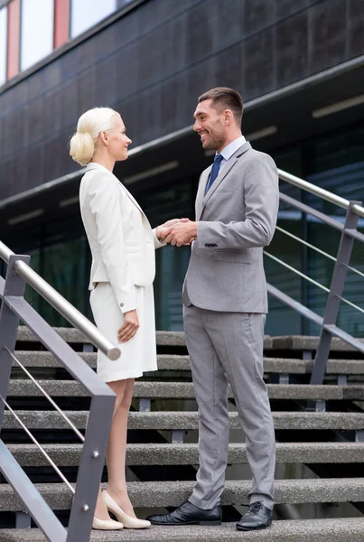 Smiling businessmen shaking hands on street — Stock Photo, Image