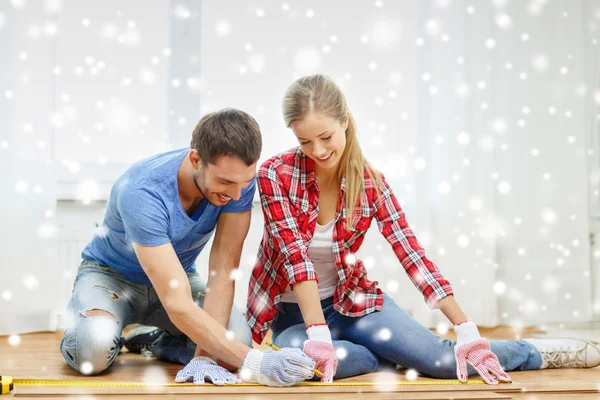 Lächelndes Paar beim Messen von Holzböden — Stockfoto