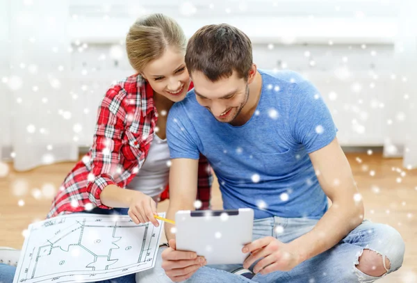 Couple souriant avec tablette et plan à la maison — Photo