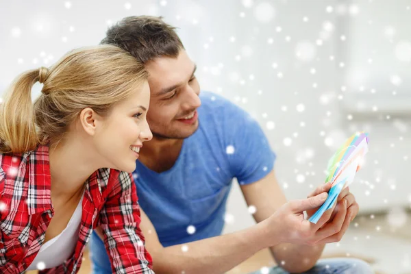 Casal sorrindo selecionando cor de amostras — Fotografia de Stock