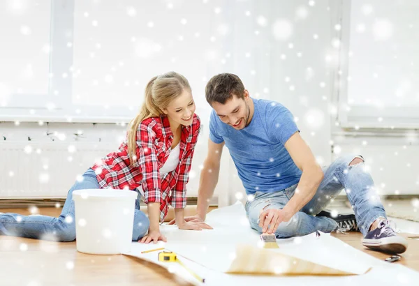 Smiling couple smearing wallpaper with glue — Stock Photo, Image