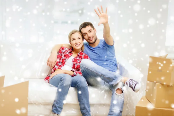 Sonriente pareja relajante y saludando la mano en casa — Foto de Stock