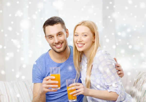 Sorrindo casal feliz em casa beber suco — Fotografia de Stock