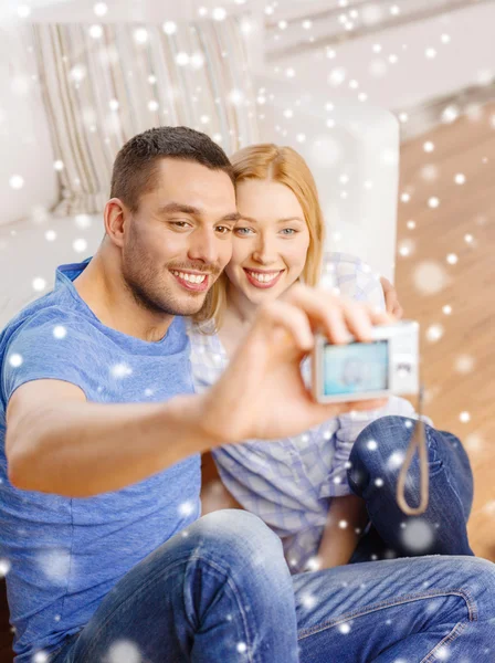 Smiling couple taking picture with digital camera — Stock Photo, Image