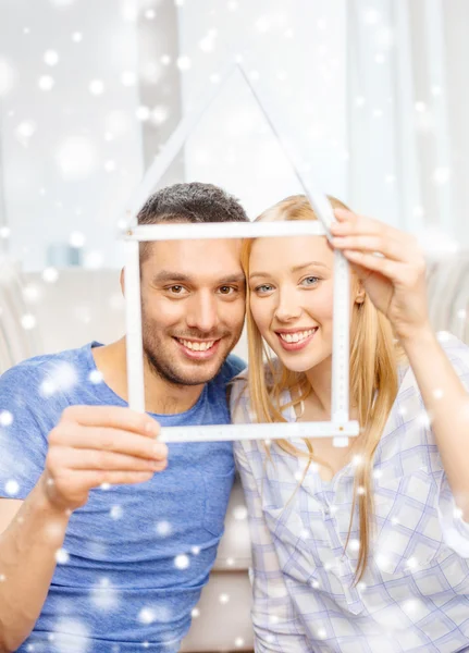 Sorrindo casal segurando modelo de casa em casa — Fotografia de Stock