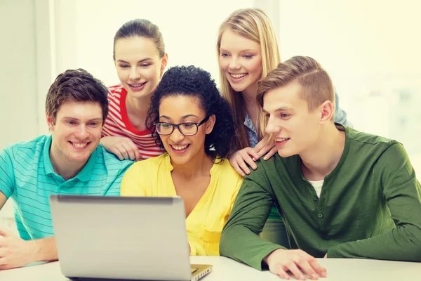 Leende studenter titta på laptop på skolan — Stockfoto