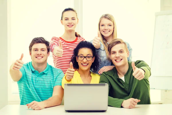 Smiling students with laptop at school — Stock Photo, Image