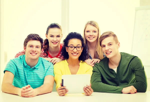 Lachende studenten met tablet pc-computer op school — Stockfoto