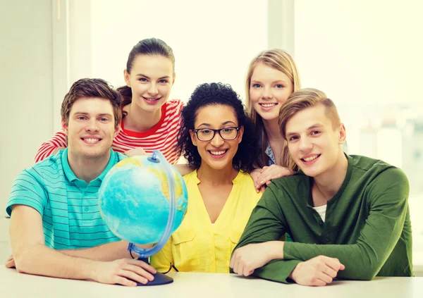 Cinco estudiantes sonrientes con globo terráqueo en la escuela — Foto de Stock