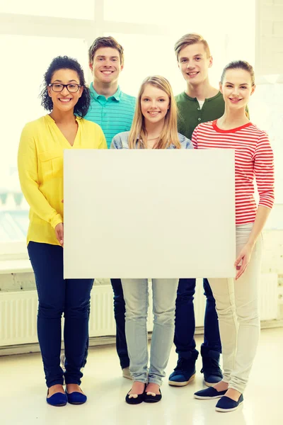 Lächelnde Schüler mit weißer Tafel in der Schule — Stockfoto