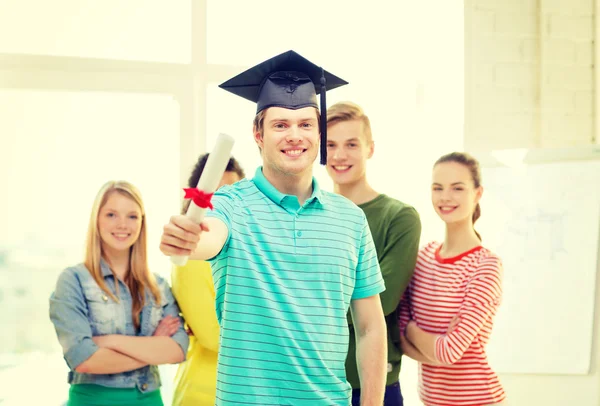 Studente maschio sorridente con diploma e tappo ad angolo — Foto Stock