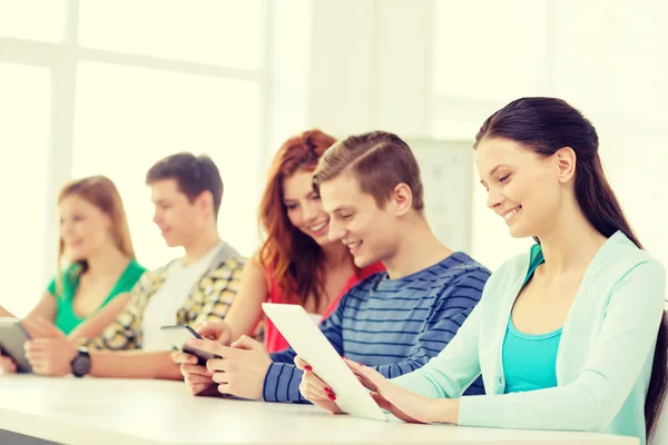 Estudantes sorridentes com tablet pc na escola — Fotografia de Stock