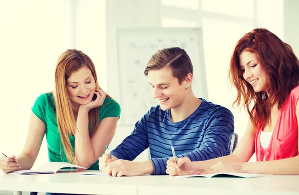 Smiling students with textbooks at school — Stock Photo, Image