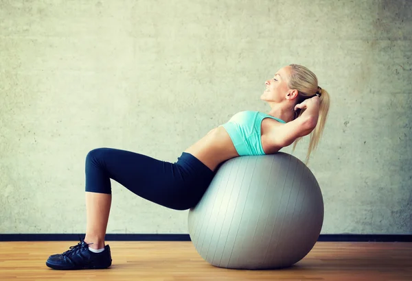 Leende kvinna med övning boll i gym — Stockfoto