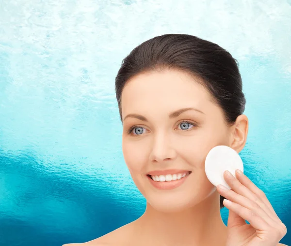 Uśmiechnięta kobieta czyszczenia skóry twarzy z wacikiem — Zdjęcie stockowe