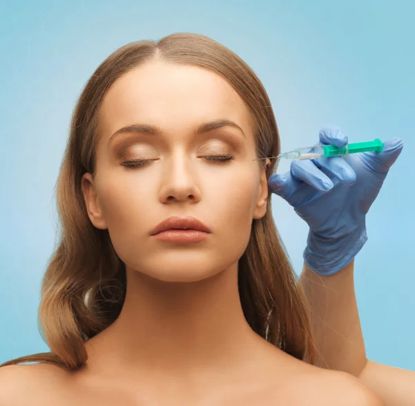 Krásná žena obličej a ruce s injekční stříkačkou — Stock fotografie