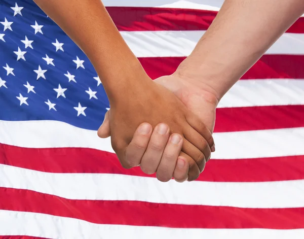 Närbild på händer som håller över amerikanska flaggan — Stockfoto