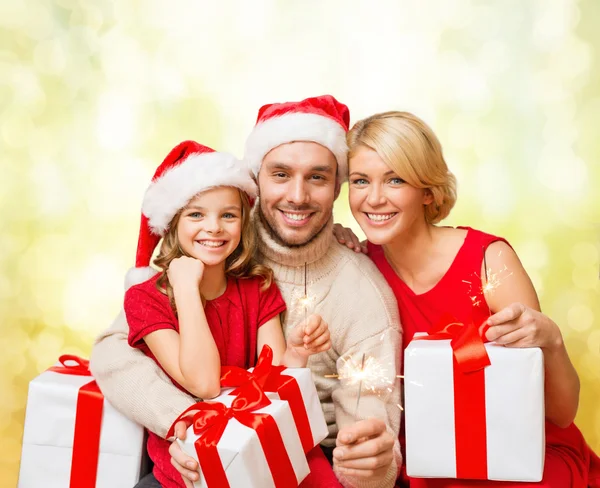 Sorrindo família segurando caixas de presente e brilhos — Fotografia de Stock