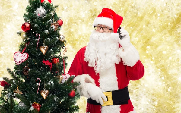 Santa claus s smartphone a vánoční stromeček — Stock fotografie